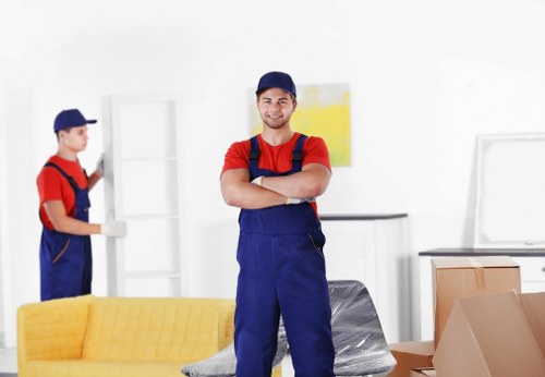 Professional man and van team using PPE while loading furniture safely