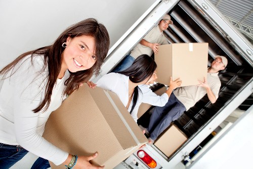 Professional movers carrying items through a narrow stairwell
